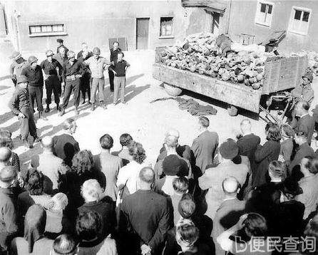 德国魏玛的居民被美军带到布痕瓦尔德，右边的卡车上装满了尸体。